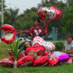 Selling Mother's Day balloons along roadside.
